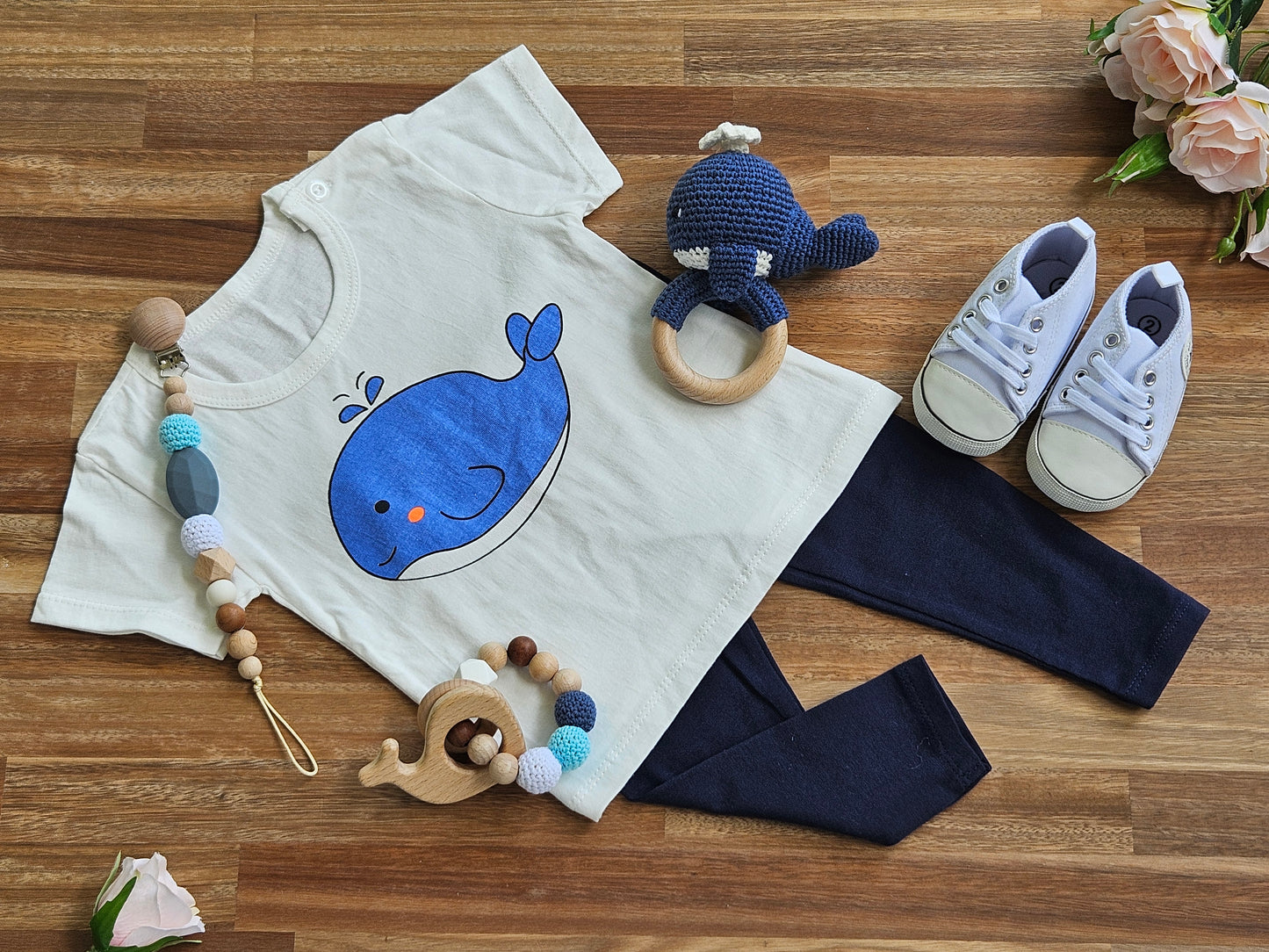 White T-Shirt with whale image and navy blue leggings White jogger shoe, Crocheted whale rattle, Beaded teether toy ring with whale teether toy and a beaded pacifier clip