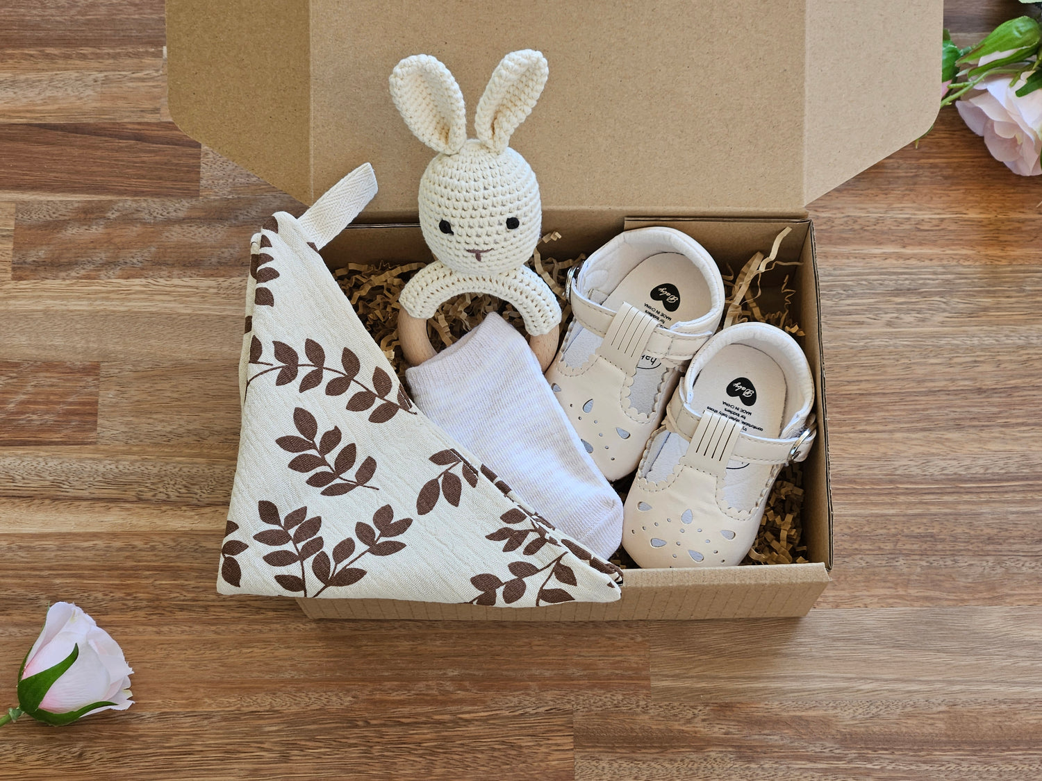 Baby gift box includes mary jane style shoe, rabbit rattle ankle sock and a muslin burp cloth