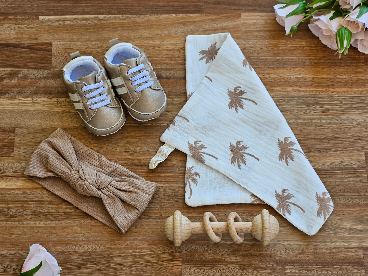 Champagne colour baby sneaker with knot headband wooden bar rattle and a muslin burp cloth