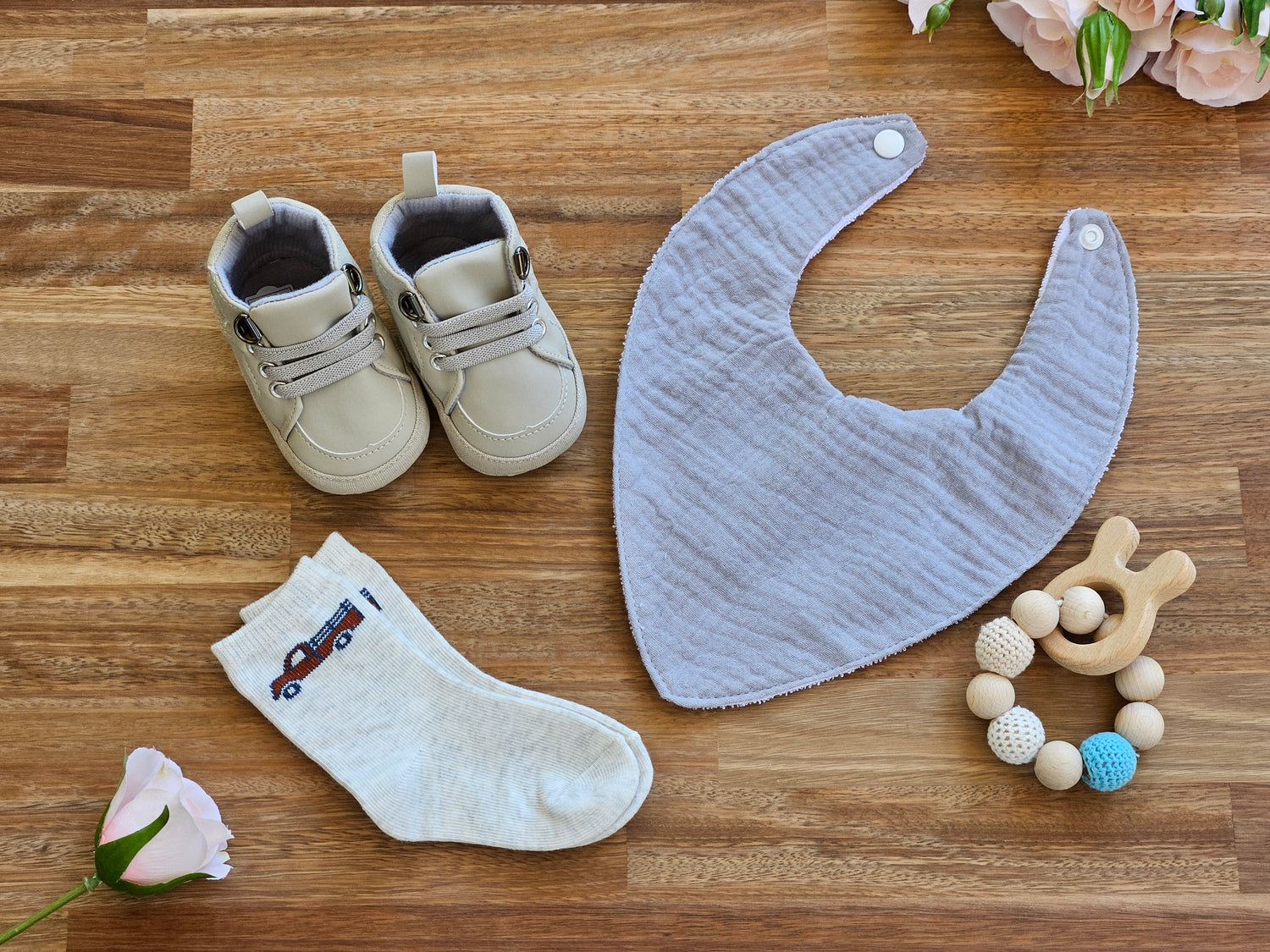 grey walking boot. sock with truck image, beaded teether ring and grey waterproof bib