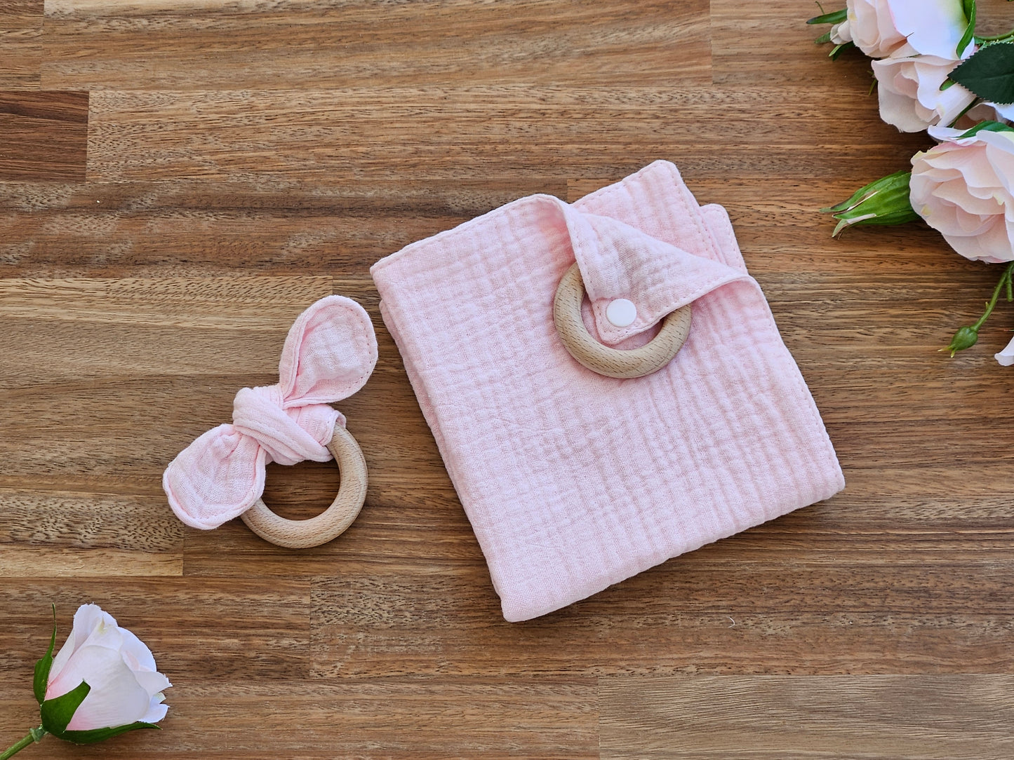 Pink muslin dribble cloth and a bunny ear teether ring