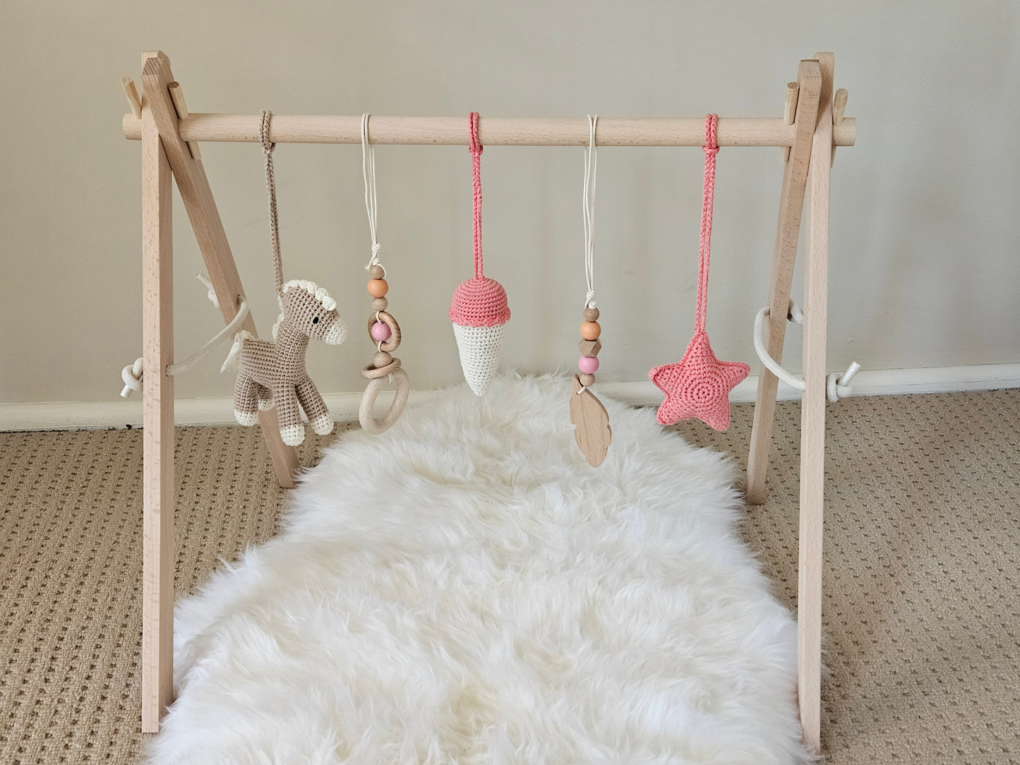 Carnival themed wooden gym with 5 toys, Horse, Ice
cream, Star and 2 wooden hanging toys with beads.