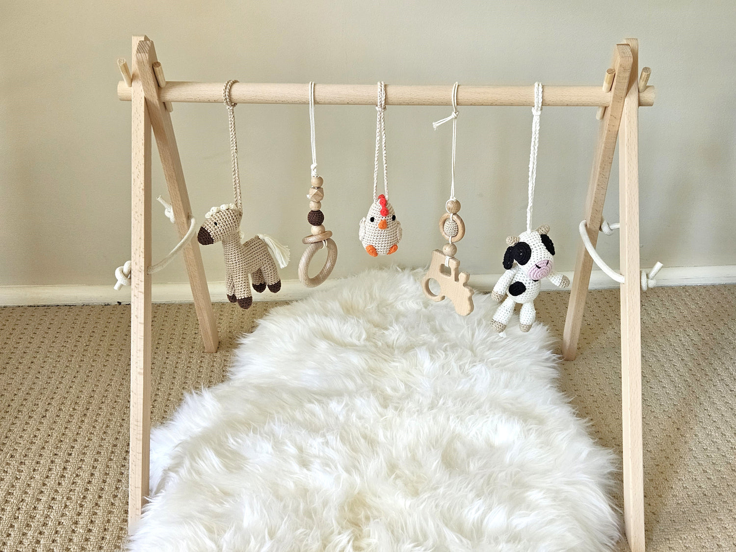 Farmyard themed wooden baby gym with 5 toys, Crochet beige horse, crochet Chicken, crochet Cow and 2 wooden hanging toys ring and tractor.